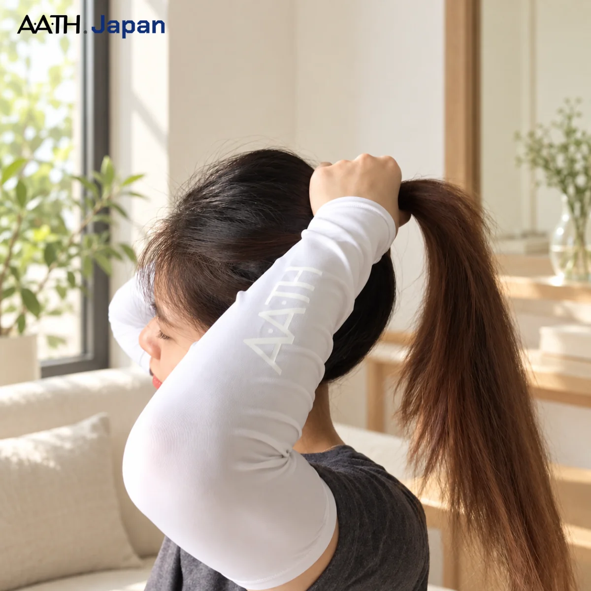 cận cảnh người mẫu mang tất ống tay nano aath màu trắng ngồi buộc tóc