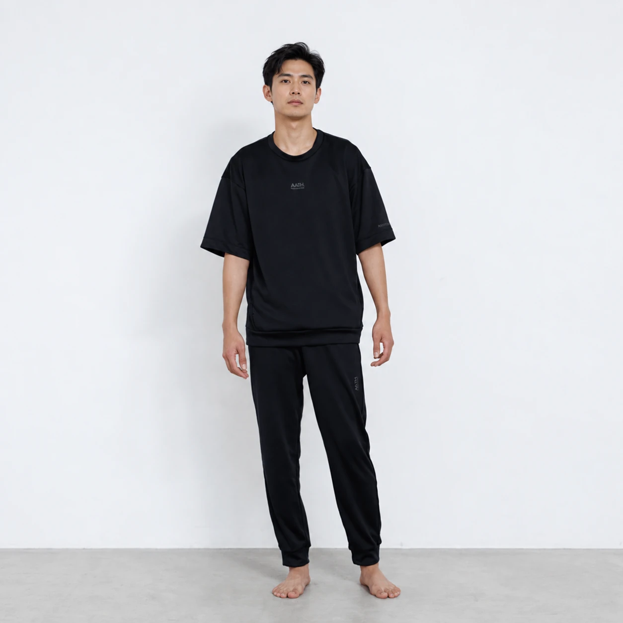 người mẫu nam mặc áo nỉ thun và quần jogger AATH Photontech màu đen nhìn phía trước