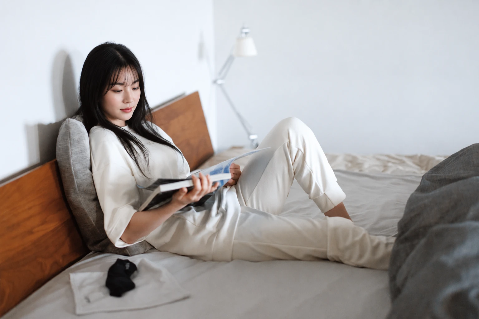 người mẫu nữ mặc áo nỉ thun và quần jogger AATH Phottontech màu trắng đang đọc sách